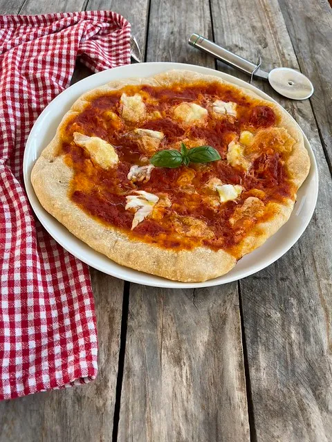 Pizza napoletana preparata con il Bimby e cotta in forno, condita in modo classico con pomodoro e mozzarella